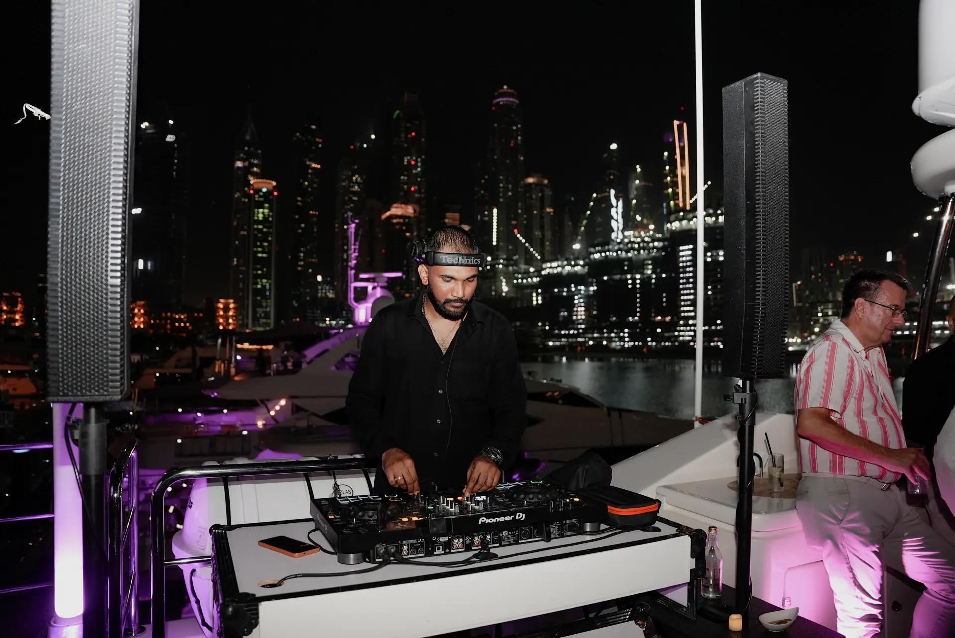 DJ at night with Marina lights